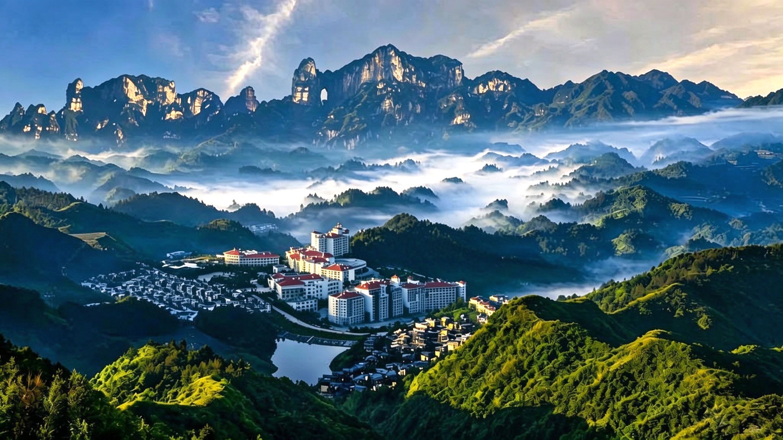 A resort with multiple buildings, a lake, and mountainous terrain.