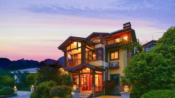 A multi-story house with a porch, a driveway, and a landscaped garden. - Avatar Valley Grand Hotel (Zhangjiajie)