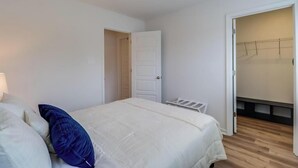 A bedroom with a bed, a door, and a walk-in closet. - Cozy Gulfport Beach Home - Seahorse Harbor (Gulfport)