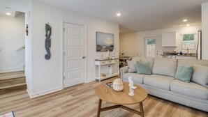 A living room with a sofa, a coffee table, and a painting on the wall. - Cozy Gulfport Beach Home - Seahorse Harbor (Gulfport)