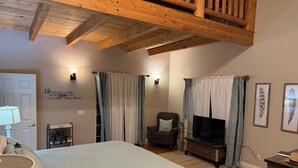 A bedroom with a bed, a chair, a TV, and a wooden ceiling. - Serene 4-bedroom  spacious house in Pagosa Springs perfect for your getaway. (Pagosa Springs)