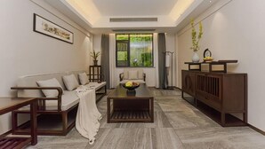 A modern living room with a sofa, coffee table, and a cabinet. - Serene Peaks Courtyard (Xiangxi)