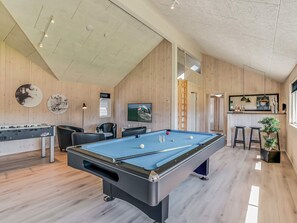 A pool table in a room with wooden walls and a sloped ceiling. - 5 Star Holiday Home in Norre Nebel (Norre Nebel)