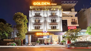 Ein Hotel mit einem auffälligen 'GOLDEN Suites'-Schild, einer modernen Fassade und einem gut sichtbaren Eingang.