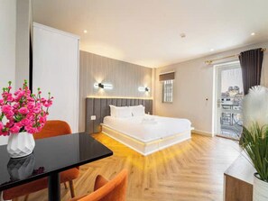 Una habitación de hotel con una cama, un escritorio y una silla.