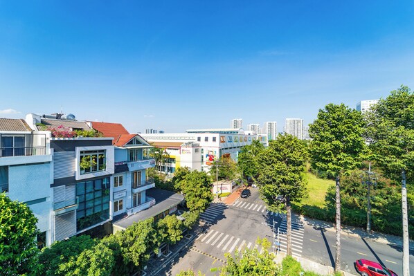 A modern building with a flat roof, large windows, and a crosswalk. - Golden Suites Saigon (Ho Chi Minh City)