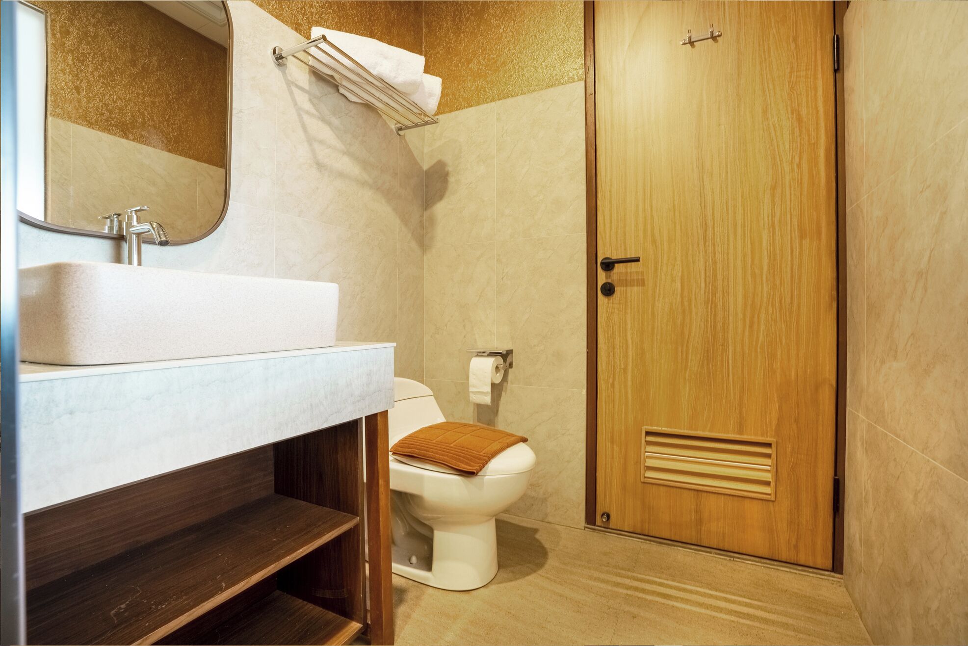 Une salle de bain avec un lavabo, des toilettes et une porte en bois.
