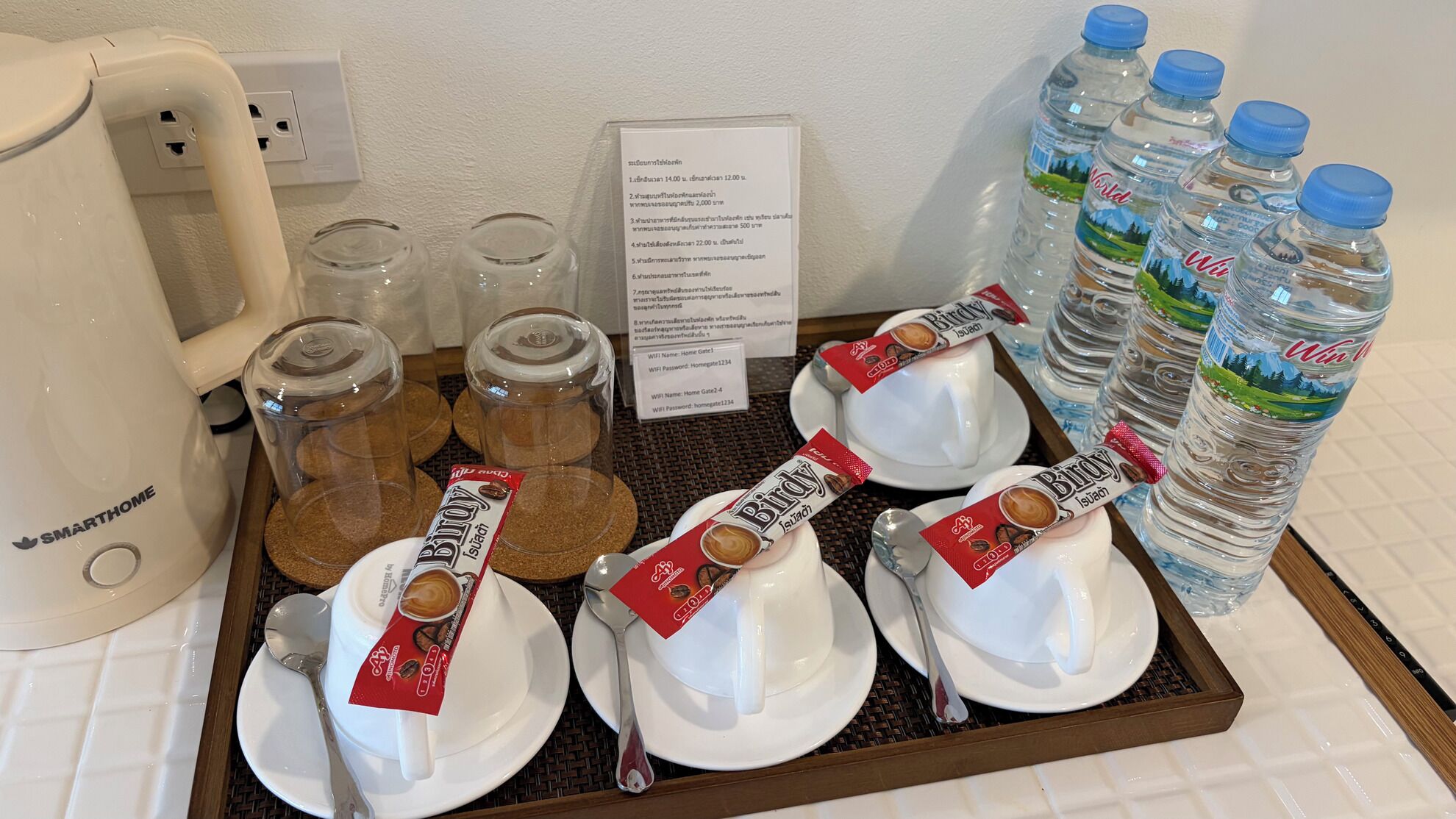 Een dienblad met koffiekopjes, suikerzakjes en waterflessen.