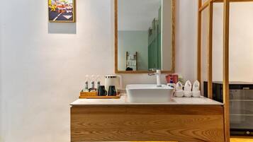 Ein modernes Badezimmer mit einem Holzbadschrank, einem großen Spiegel und einem Waschbecken.