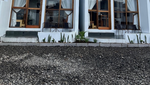 A modern two-story building with large windows and wooden beams. - Sanctuary House (Dieng Kulon)