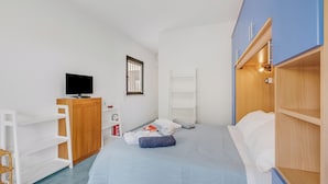 A bedroom with a bed, a TV, a wardrobe, and a shelf unit. - Casetta Azzurra Flat With Parking in Capalbio (Capalbio)