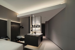 A modern hotel room with a large bed, a bedside table, a desk with a computer, and a bathroom with a large mirror and a vanity. - Atour Hotel Shanghai Yuyuan Yaduo  Bund (Shanghai)