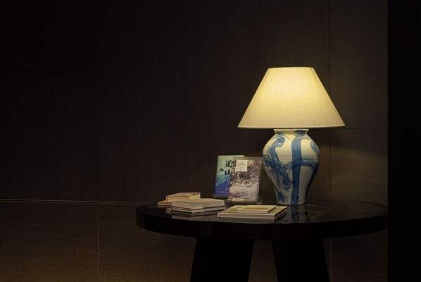 A round table with a lamp, books, and a vase. - Atour Hotel Shanghai Yuyuan Yaduo Bund (Shanghai)