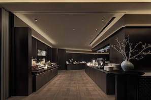 A modern, dimly lit bar area with a long counter, recessed lighting, and a decorative vase. - Atour Hotel Shanghai Yuyuan Yaduo  Bund (Shanghai)