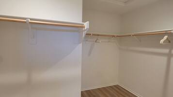 A room with a wooden floor, white walls, and a ceiling with a recessed light fixture.