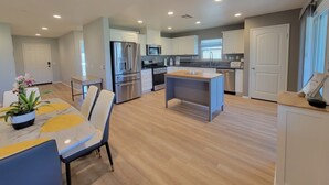 Una cocina moderna con armarios blancos, electrodomésticos de acero inoxidable y una isla central.