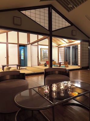 Une pièce de style japonais traditionnel, avec un sol recouvert de tatamis, un plafond bas et des portes coulissantes.