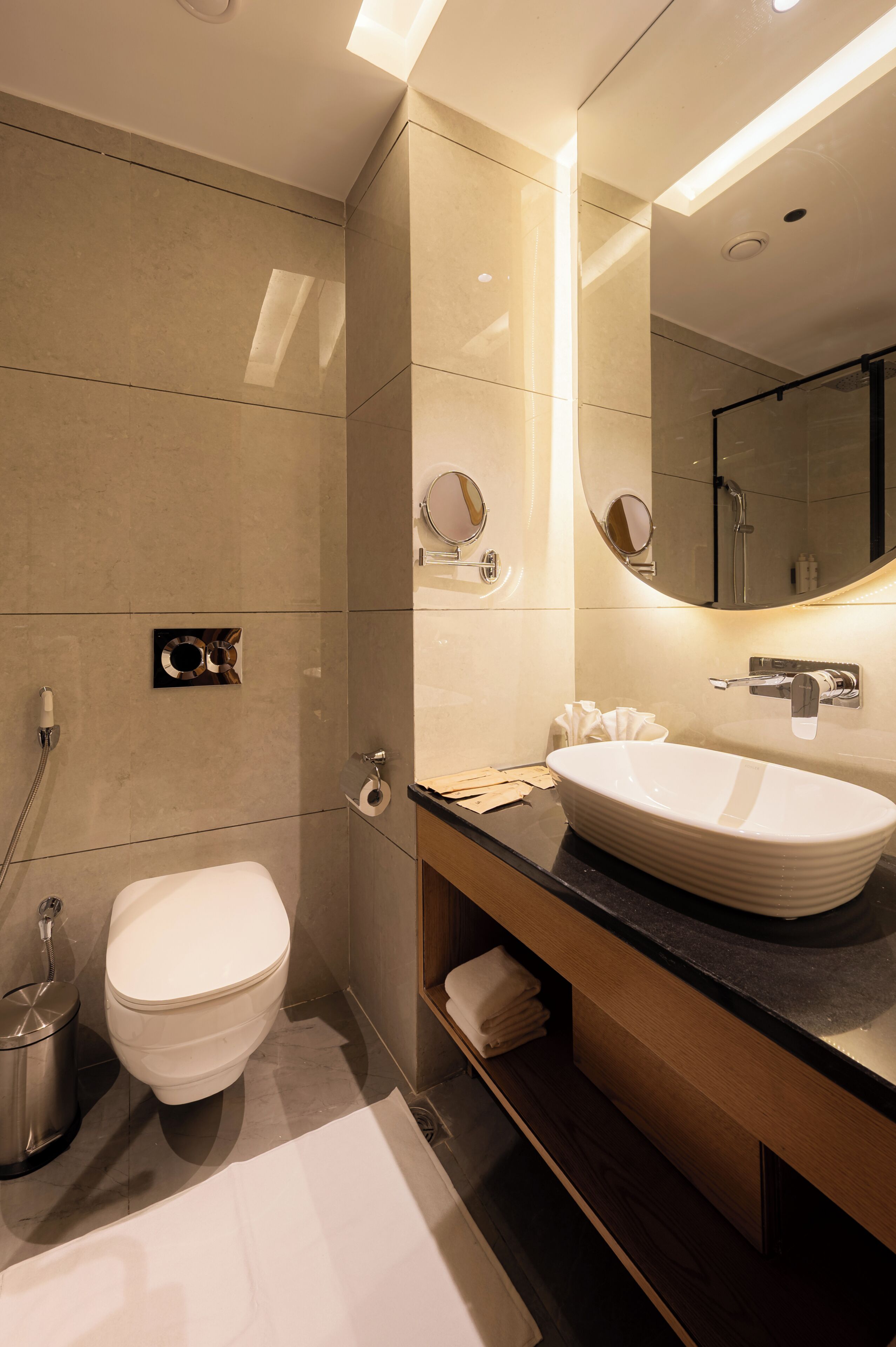 A modern bathroom with a large sink, toilet, and shower.