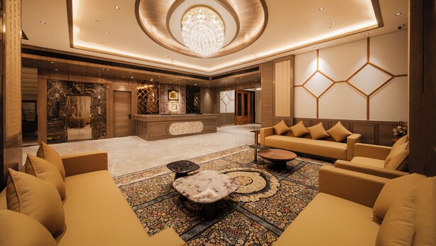A spacious lobby with a central seating area, a reception desk, and a chandelier. - Ananta Express (Katra)