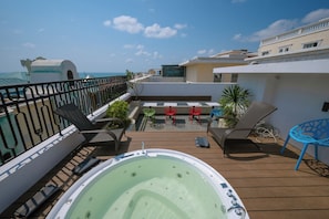 A rooftop deck with a hot tub, lounge chairs, and a view of the ocean. - Casa Del Mar Boutique Hotel (Phu Quoc)