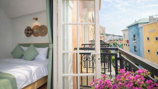 Ein Balkon mit einem Bett, Blick auf die Stadt und einer Brüstung.