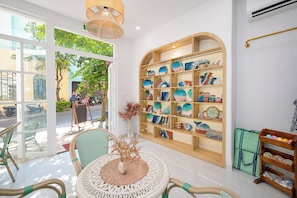 A modern interior with a glass door leading outside, wicker furniture, and a wall display of ceramic plates.