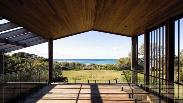 Un pontile di legno con vista sull'oceano e sul verde.