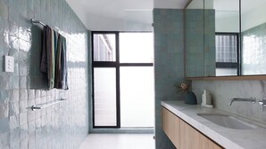 Un bagno moderno con un'ampia finestra, un lavabo in marmo e un porta asciugamani.