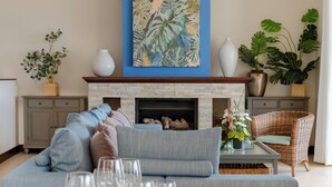 Un salon doté d’une cheminée, d’un mur d’accent bleu et de diverses plantes.