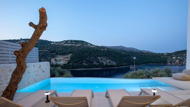 Una piscina d'hidromassatge sense fi amb gandules i vistes a un llac i les muntanyes.