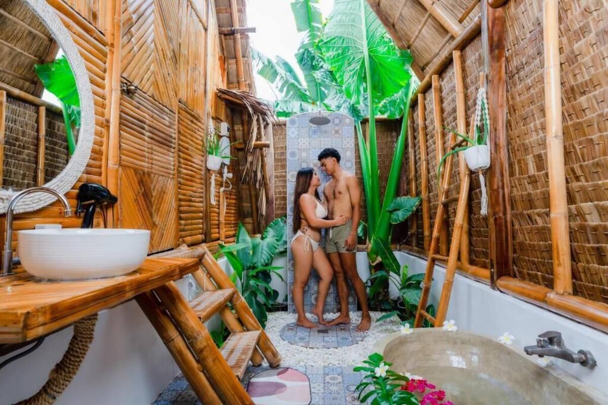 Un baño con temática de bambú, que incluye una zona de ducha y un lavabo.