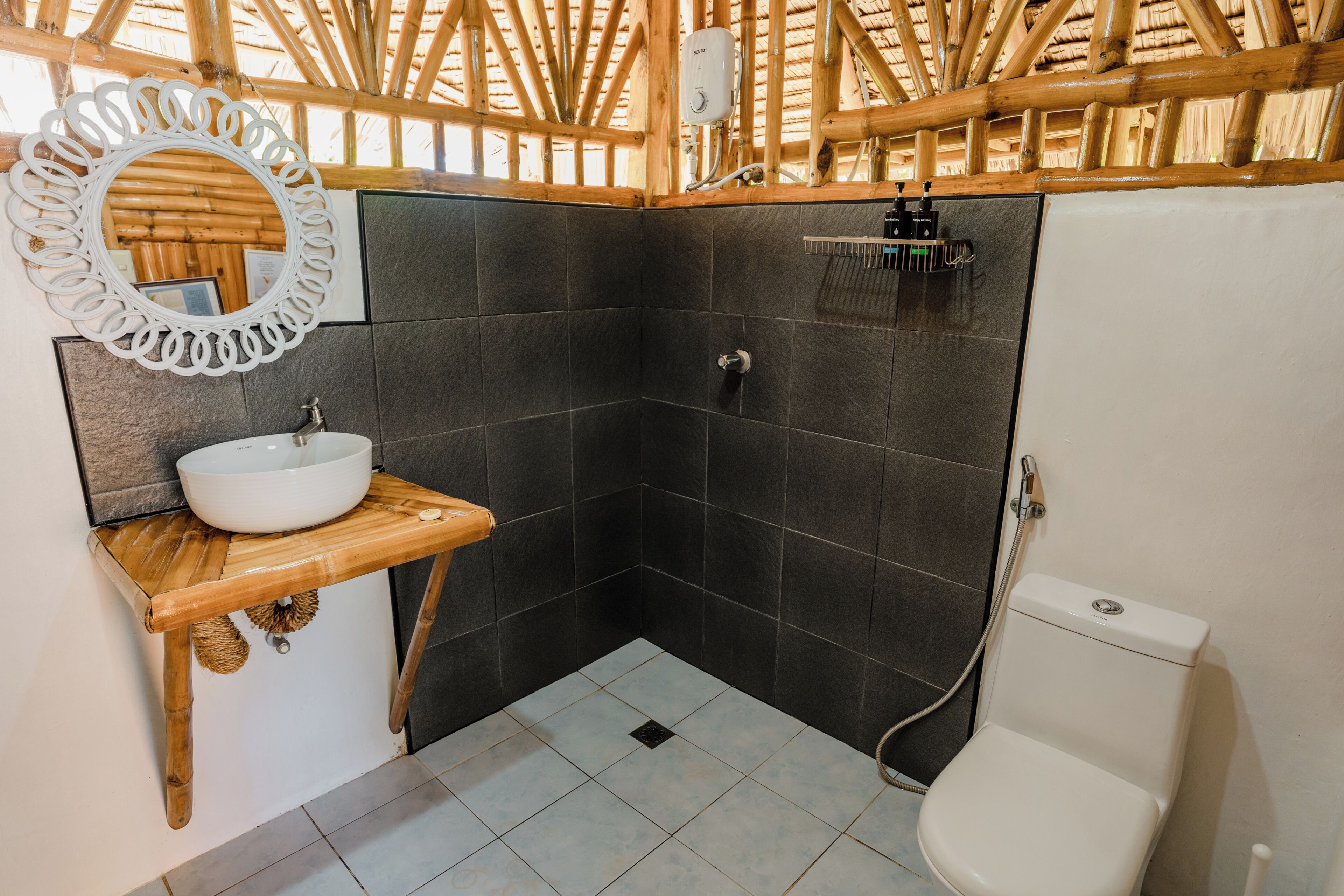 Ein Badezimmer mit Holzboden, einem weißen Waschbecken, einem Spiegel und einer Toilette.