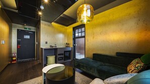 Un intérieur moderne avec un canapé, une table ronde et un luminaire suspendu.
