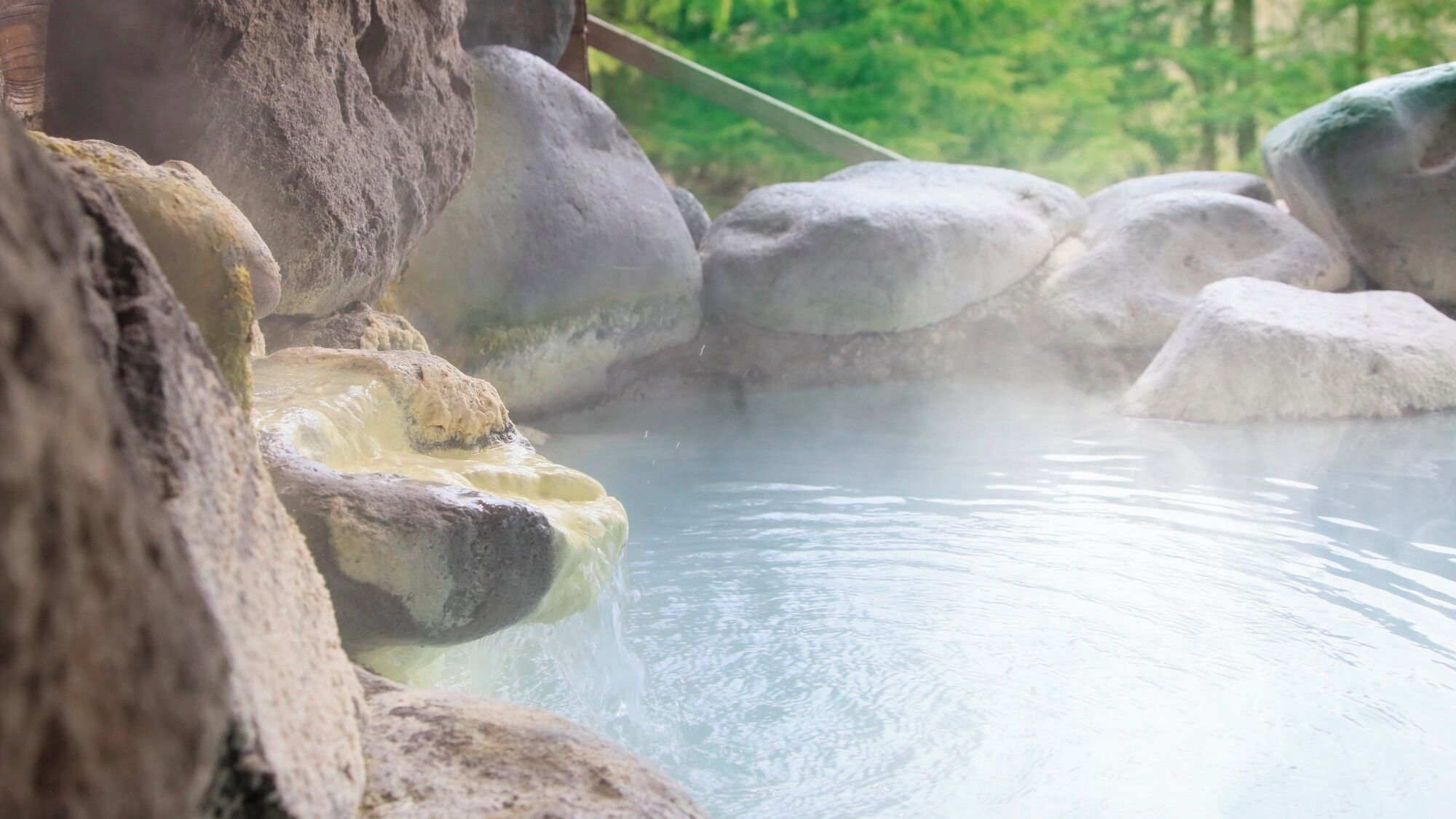 A hot spring with large rocks surrounding the water.