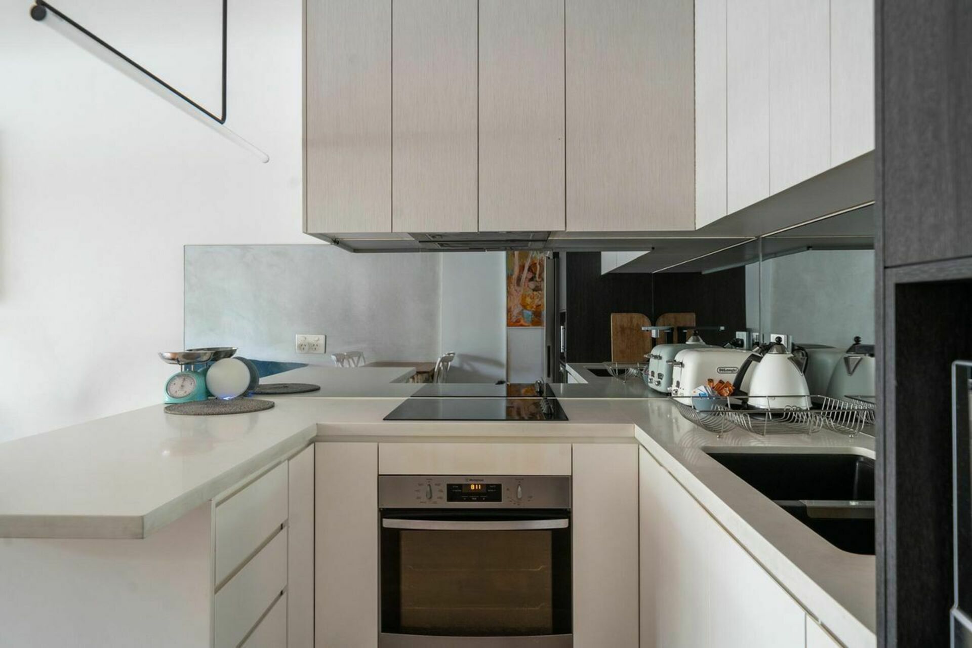 A modern kitchen with a built-in oven, a dishwasher, and a coffee machine.
