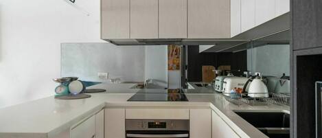 A modern kitchen with a built-in oven, a dishwasher, and a coffee machine.