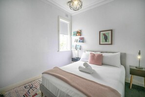 A bedroom with a bed, bedside table, wall art, and a window. - Sleek Tempe Pad near SYD Airport & Transit (Tempe)