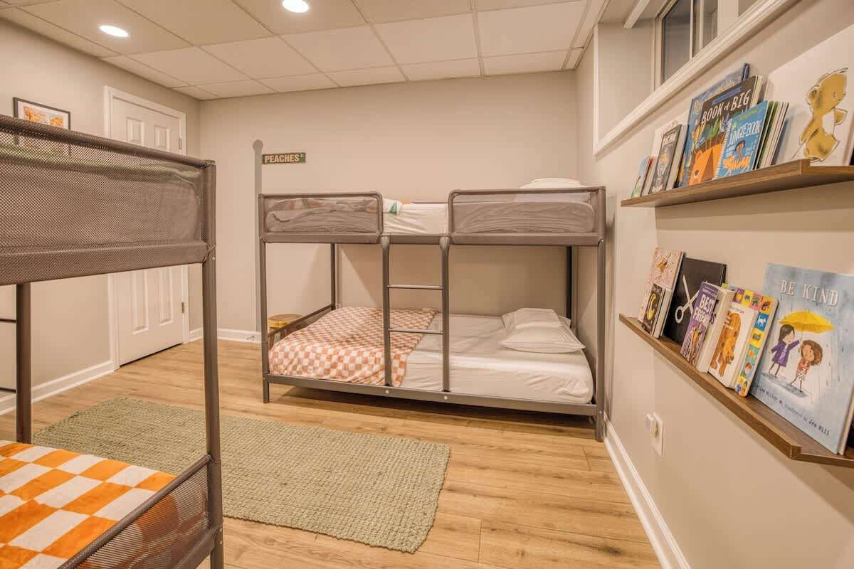 Quarto com beliche, uma estante e uma porta com a etiqueta 'PEACHES'.