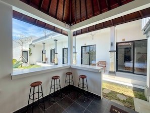 Ein modernes Interieur mit Barbereich, Sitzgelegenheiten und Blick ins Freie.