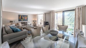 Una sala moderna con una mesa de vidrio, un sofá y un televisor.