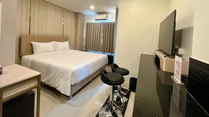 Una habitación de hotel con cama, televisión, escritorio y baño.