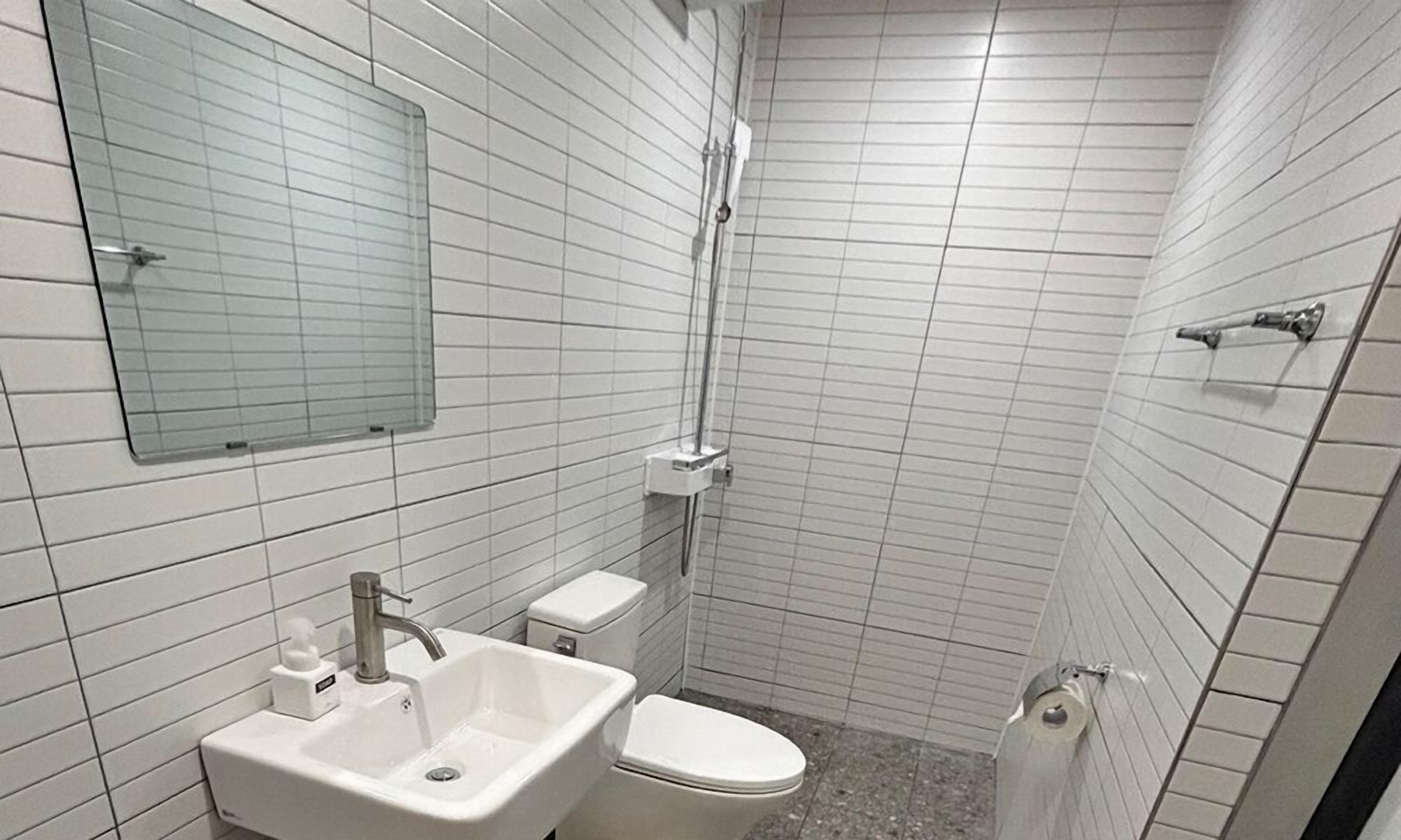 Ein kleines Badezimmer mit Waschbecken, Toilette und Dusche.