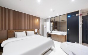 A modern hotel room with a large bed, a bathroom with a mirror and sink, and a dark door. - Brown Dot Hotel Pyeongtaek Godeok (Pyeongtaek)