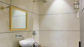 A bathroom with a toilet, sink, mirror, shower, and ceiling fan. - Homestay By cafe9 (Amritsar)