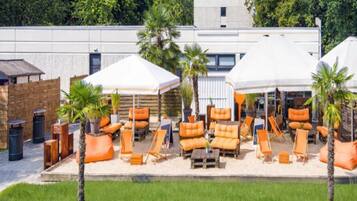 A rooftop lounge area with outdoor seating and umbrellas.