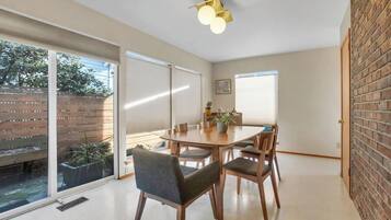 A dining area with a table, chairs, and a ceiling light fixture.