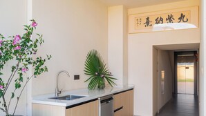 Une cuisine moderne équipée d’un lave-vaisselle, d’un évier et d’une plante en pot.