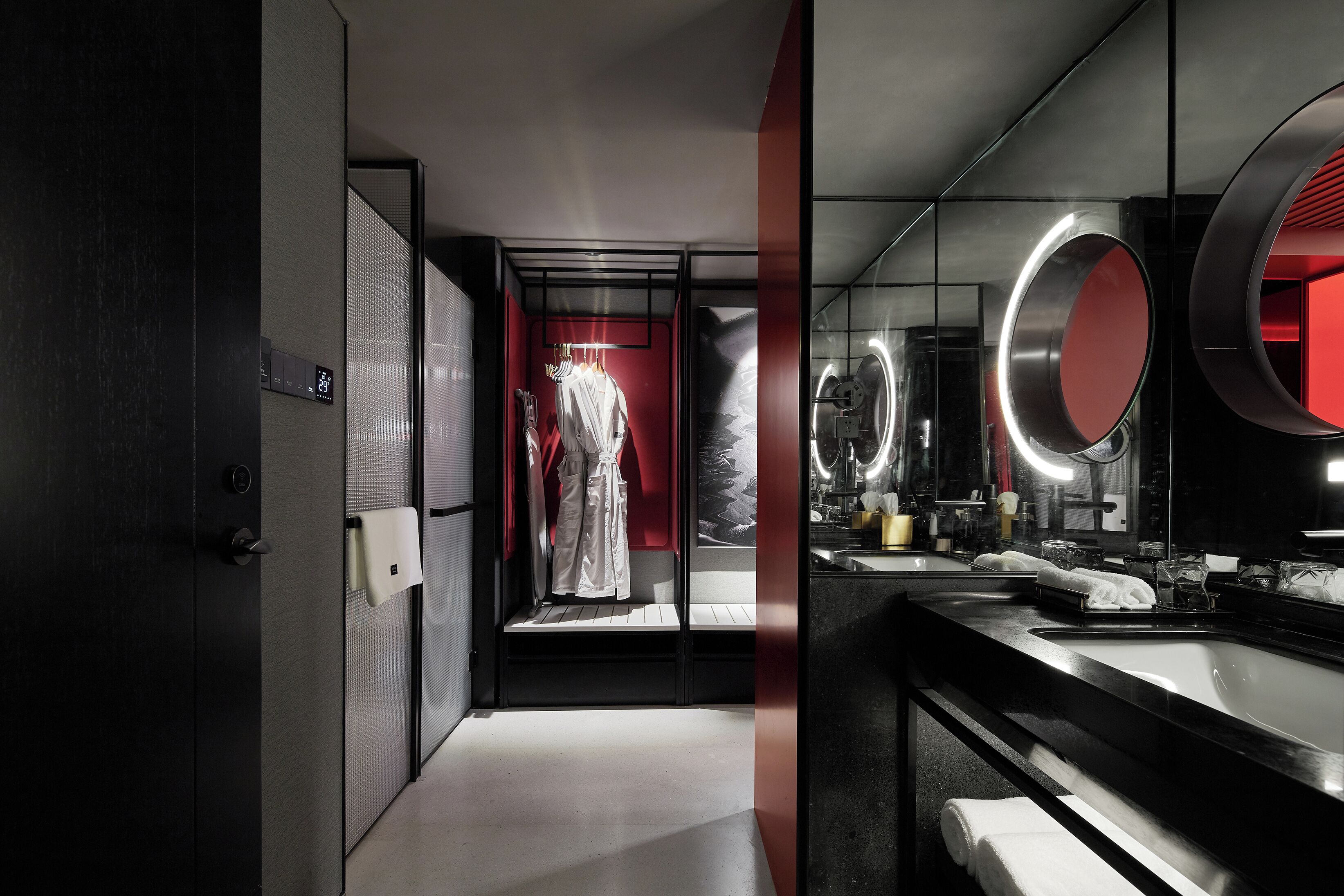 A modern bathroom with a large mirror, a towel rack, and a shower area.