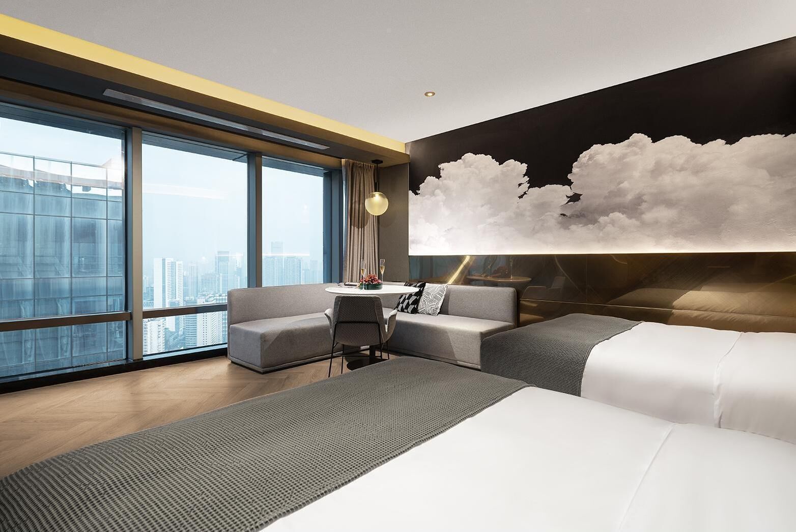 Une chambre d’hôtel moderne avec une grande fenêtre, un canapé, un bureau et un lit.