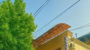 Un edificio de dos pisos con un balcón, un letrero que indica restaurante y una señal de paso de peatones.